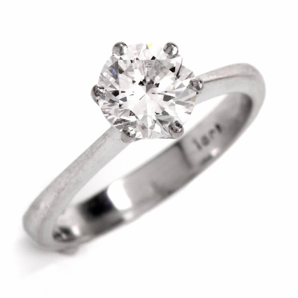 This engagement ring exposing a round brilliant-cut diamond is crafted in solid 18K white gold.  The genuine round cut diamond weighs 1.10cttw, and is graded G-H color and VS1-VS2 clarity, prong set. The sparkling diamond engagement ring remains in