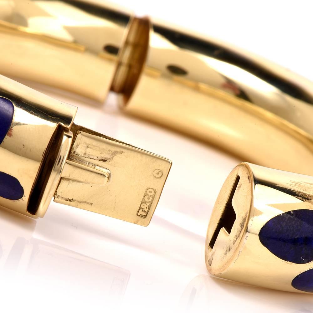 This collectible Tiffany & Co. bangle bracelet circa 1980's is crafted in 18K yellow gold by Angela Cummings, featuring chic fluid shapes inlaid with genuine lapis lazuli. This item is in excellent condition.

Measurements: 15mm width 13mm high.