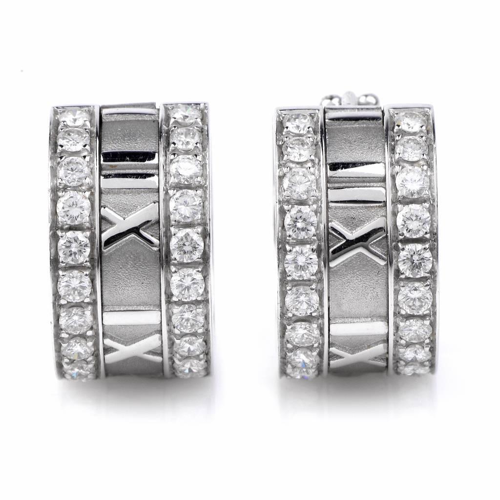 These classic diamond huggies hoop earrings are crafted in solid 18K white gold and weigh approx. 14.2 grams. These sparkling hoop earrings feature a lovely roman numerals design adorned with 40 genuine round cut diamonds weighing cumulatively