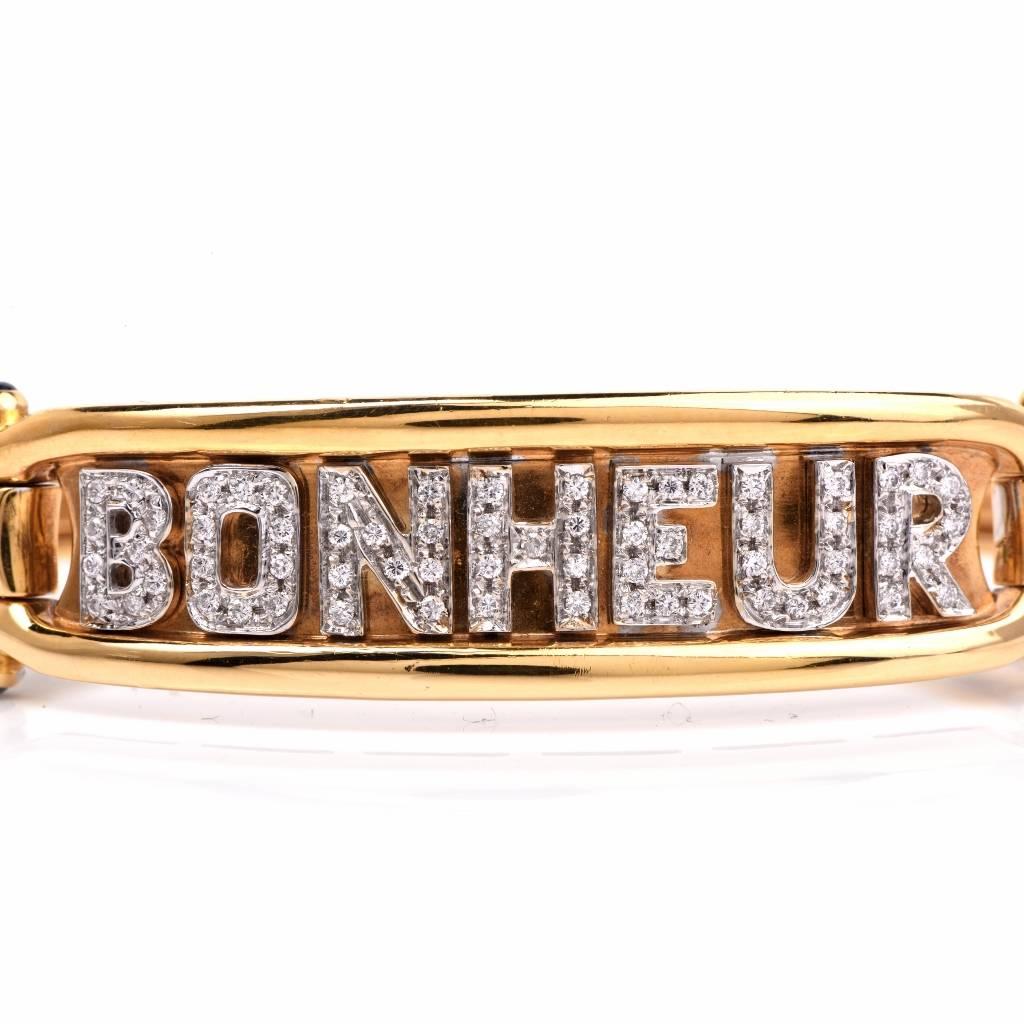 This estate bangle bracelet is crafted in solid 18K yellow gold, exposing a diamond-studded central decor, with the word 'BONHEUR' meaning 'happiness' written in capital letters, with a total of 65 genuine round-faceted diamonds, weighing