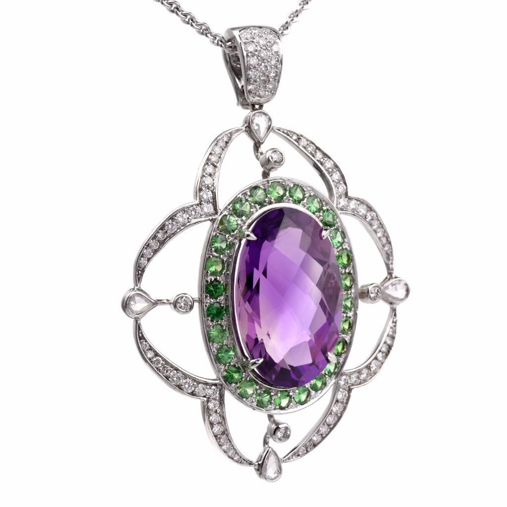 This graceful estate pendant is crafted in solid 18K white gold. Showcasing at the center an oval shape Amethyst measuring approx. 26mm x 17mm approx. 30.45cts, this pendant is adorned by some 30 round cut Tsavorite stones of approx. 3.90cts;