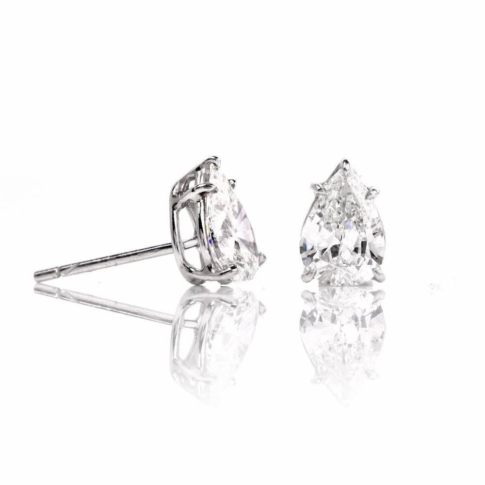 These lovely diamond stud earrings are crafted in platinum. They are set with a pair of pear cut genuine diamonds weighing approx. 1.95cttw, graded G-H color and VS1 clarity. These sparkling diamond earrings are mounted within a classic basket
