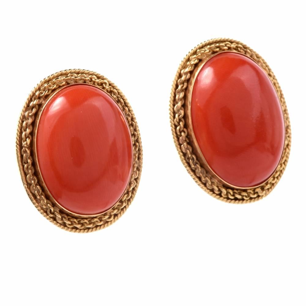 These Stylish  earrings are crafted in solid 18K yellow gold, weigh 23.6 grams and measure 27 mm x 23 mm in diameter. These alluring earrings expose a pair of Natural Redish Salmon coral  mounted in bezel within hand twisted  yellow gold borders.