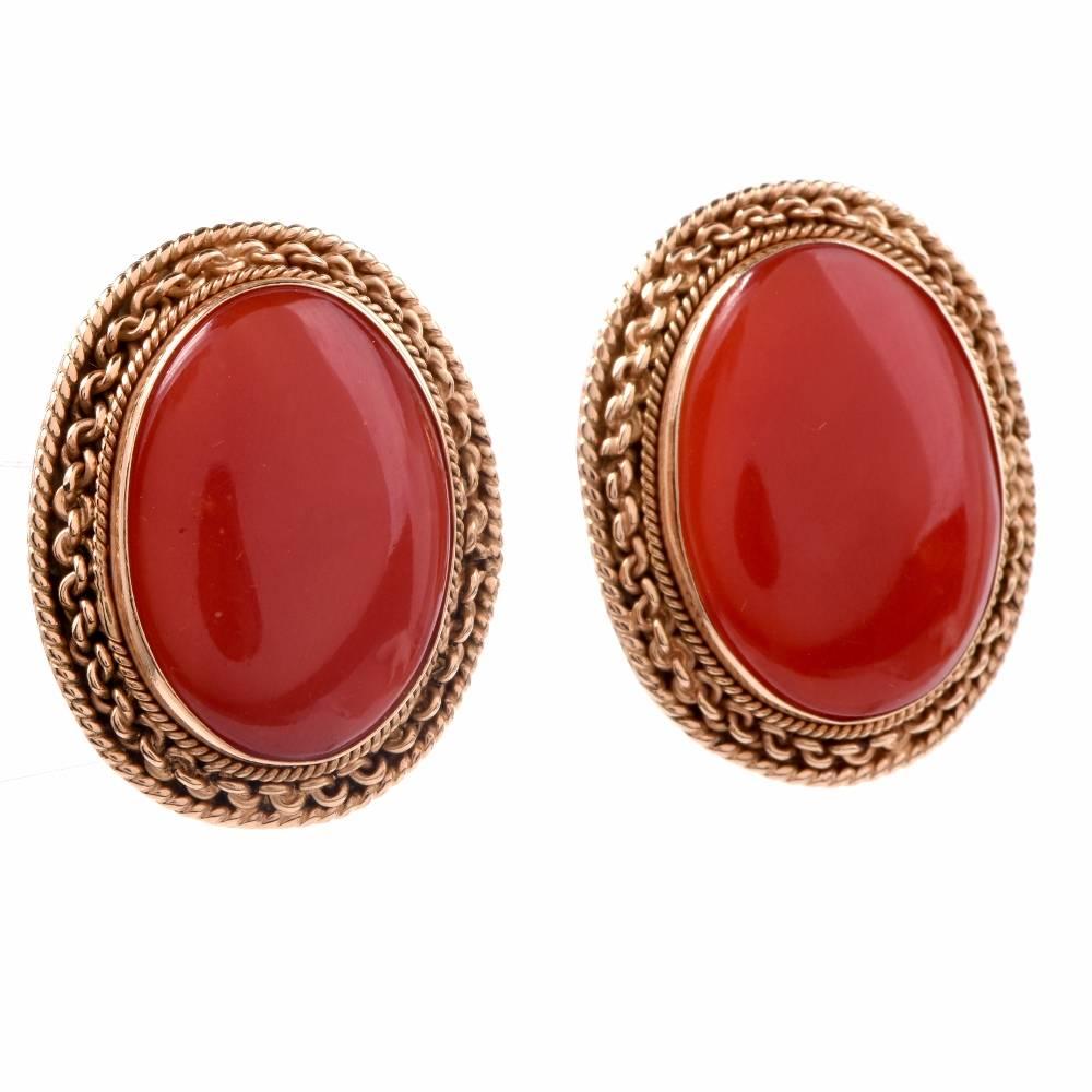 These vintage Retro earrings are crafted in solid 14K yellow gold. They expose a pair of Natural Red corals mounted in bezel within hand wire twisted yellow gold borders. These desirable earrings feature clip-backs designed for pierced ears (Posts