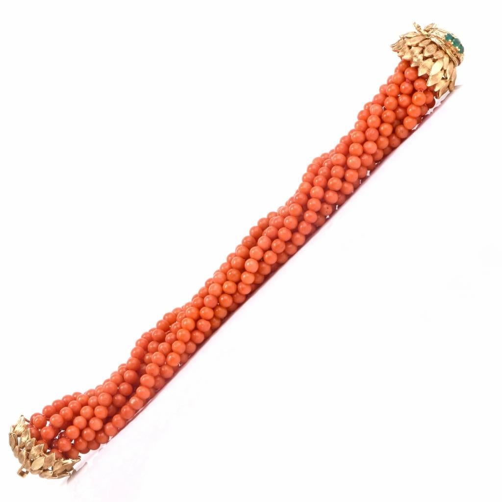 This circa1960's  coral  bracelet with a  18K yellow gold clasp incorporates 10 strands of well-matched, silk-strung red salmon color natural coral beads measuring approximately 5mm in diameter. This stylish bracelet features an elaborate textured