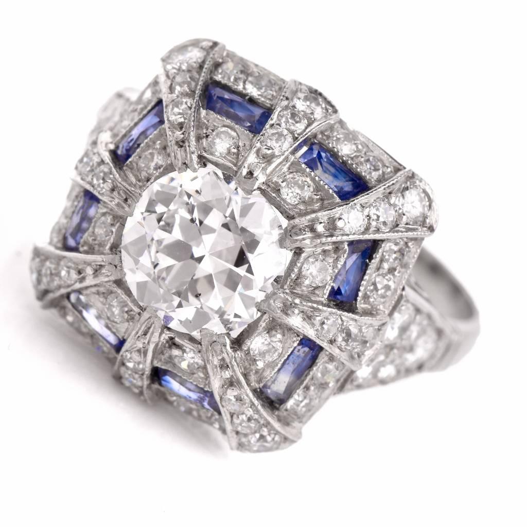 This exquisite  antique diamond sapphire engagement ring is beautifully handcrafted in solid platinum. This ring is centered with a genuine round European-cut diamond of approx 1.17cts, F color, SI1 clarity, bezel set. The mounting displays some 58