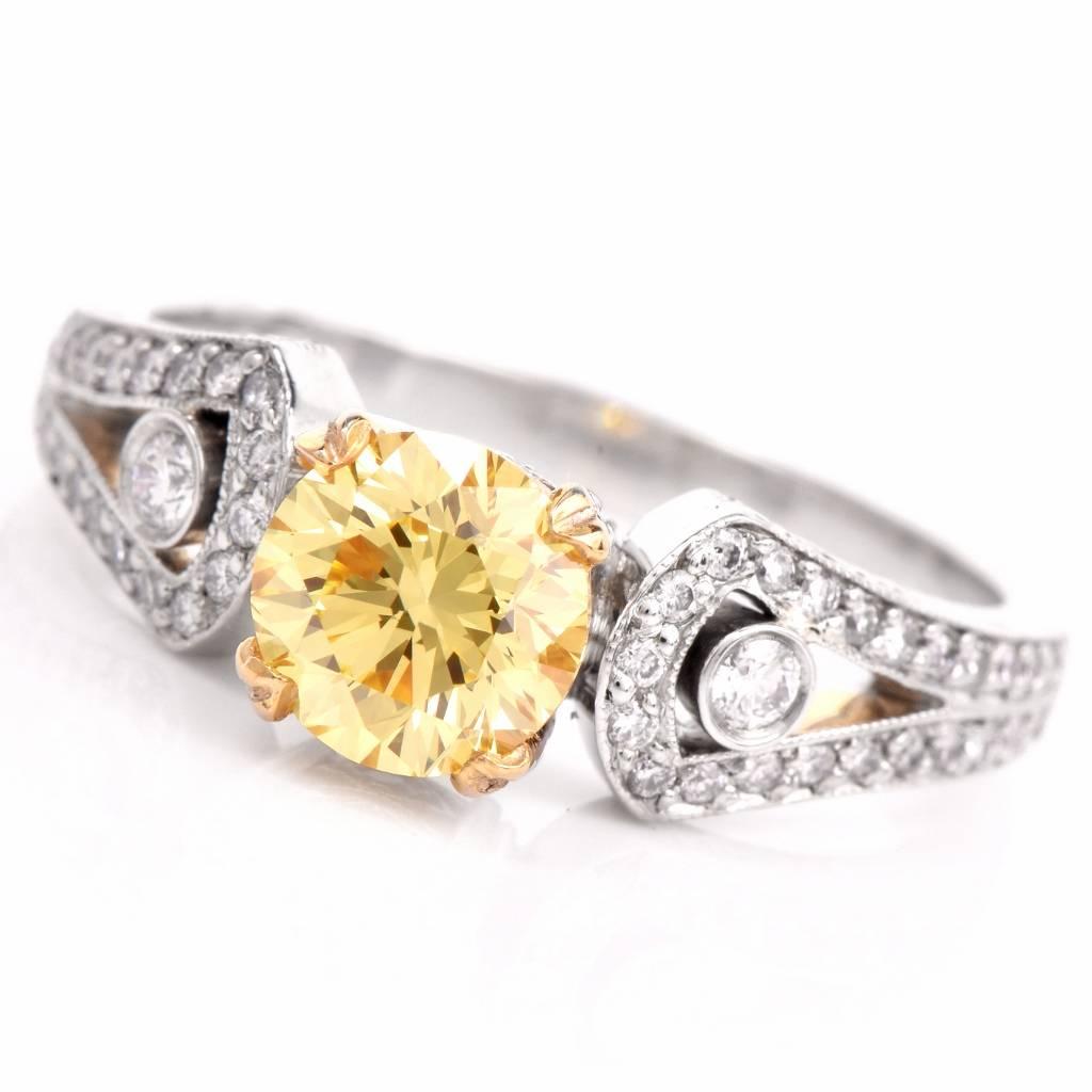 This enticing Beaudry diamond engagement ring is crafted in solid platinum and is centered with a GIA certified 1.01ct  round brilliant-cut diamond of natural fancy intense yellow color, graded VVS2 clarity. The center stone is mounted within an