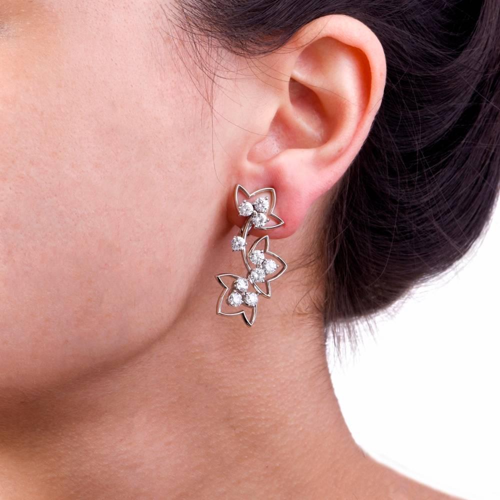 These stunning modern platinum earrings feature beautiful flower designs adorned with 20 genuine round cut large sparkling large diamonds approx: 4.15 carats, F-G color, VS1-VS2 clarity, prong set.  these are made for pierced and non pierced ears