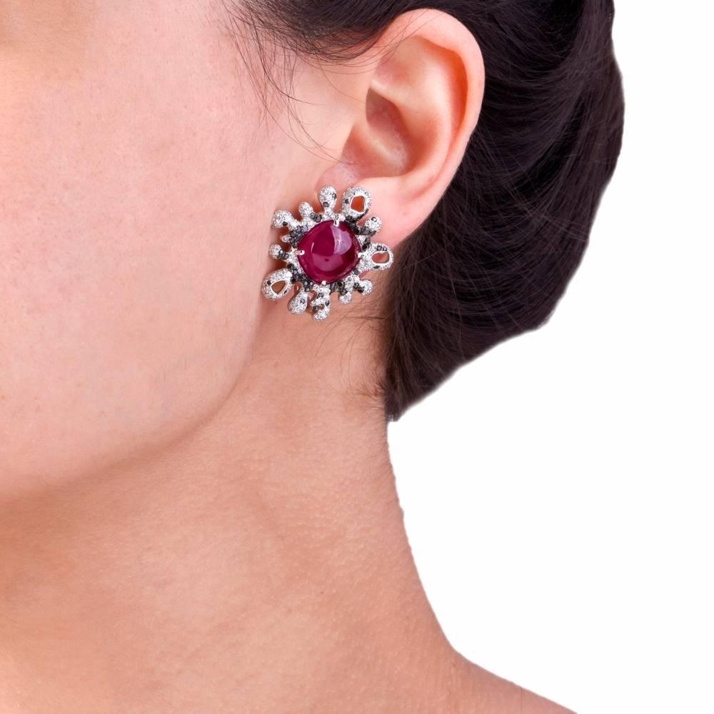 These captivating French estate earrings are crafted in solid 18K white gold, Centered with a pair of enchanting cabochon crimson-red rubies weighing approx. 20.09cts. They are surrounded by approx. 2.17cts of colorless diamonds graded G-H color,