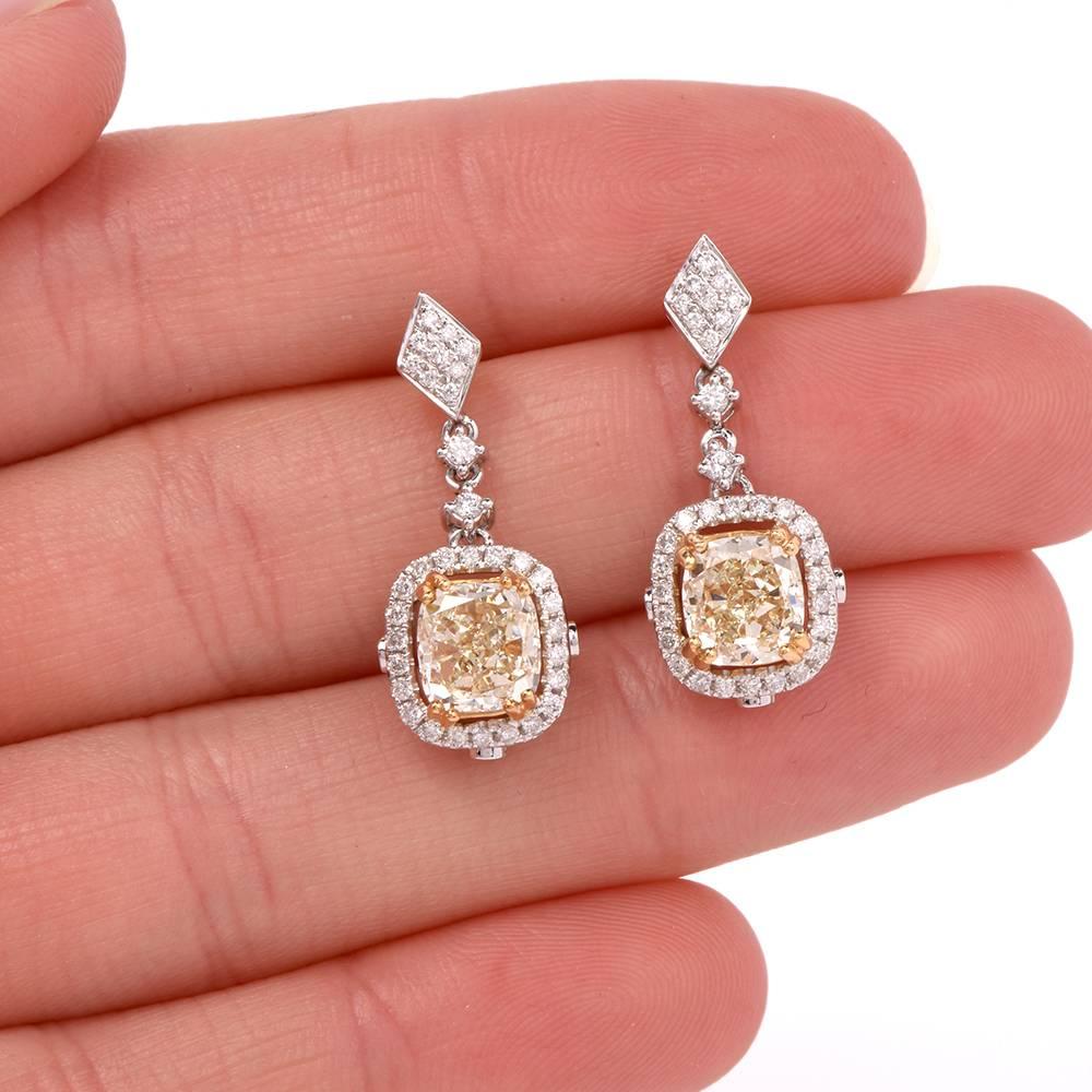 These exquisite Art Deco style fancy diamond pendant earrings are crafted in solid 18K white gold. weighing app. 8.4 grams. These earrings expose a pair of genuine cushion cut Natural fancy yellow diamond approx: 4.04cttw, VS1-VS2 clarity, mounted