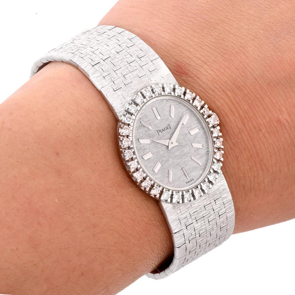 This 1960S ladies 18K white gold Piaget watch with diamonds features oval silver color dial with factory set diamond bezel.
The bezel is adorned with 28 round brilliant cut diamonds weighing approx. —-cts graded —- color and —-clarity. The watch has
