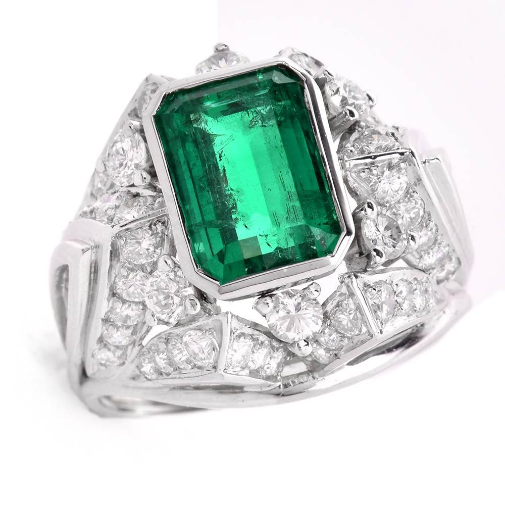 This alluring vintage cocktail ring with a GIA certified octagonal step-cut  emerald of approx: 2.85cts, graded F1, measuring 9.67 x 6.51 x 14.85 mm is crafted in solid 18K white gold. Some 54 genuine round brilliant-cut Diamonds weighing approx