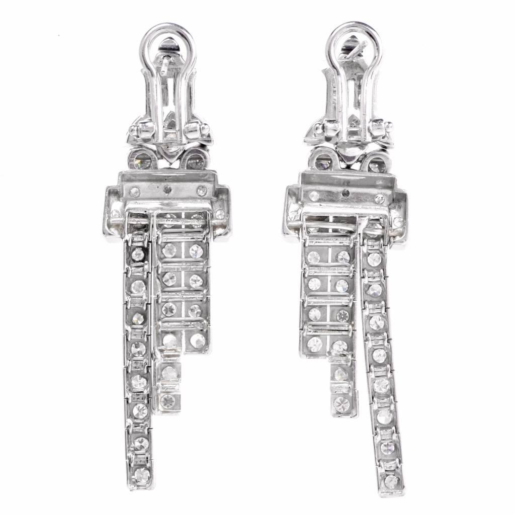 These conspicuous diamond Art Deco design earrings with geometric profiles are crafted in solid platinum, weighing Approx. 19.8 grams and measuring 52 mm x 14 mm. These elegant earrings incorporate each three cascading rows of diamond-swathed