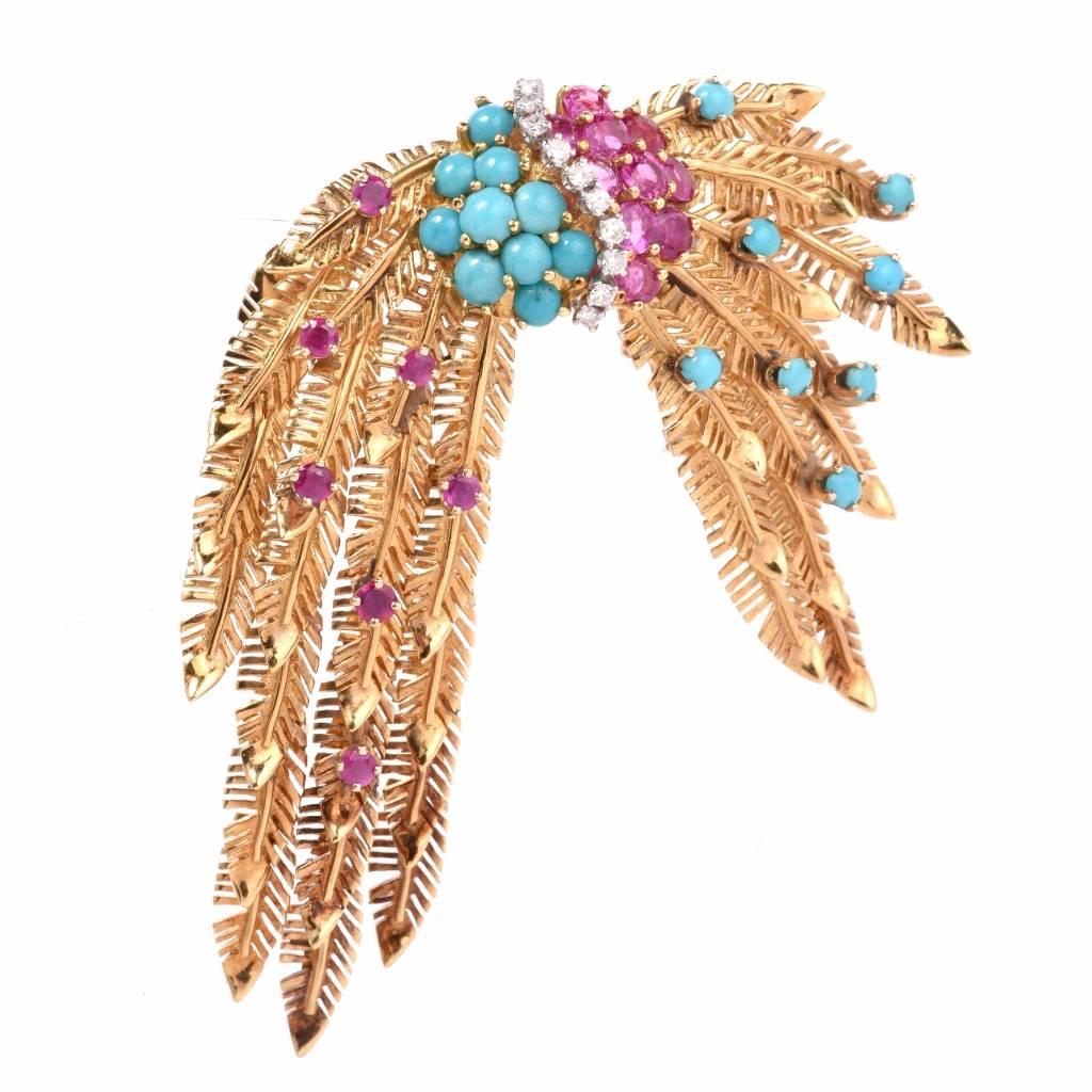 This elaborately detailed brooch is crafted in textured 18K yellow gold simulating peacock feathers. The cascading feathers are adorned with 18 round-faceted rubies, weighing 2.05cts, 10 round-faceted diamonds, weighing 0.18ct, graded H-I color and