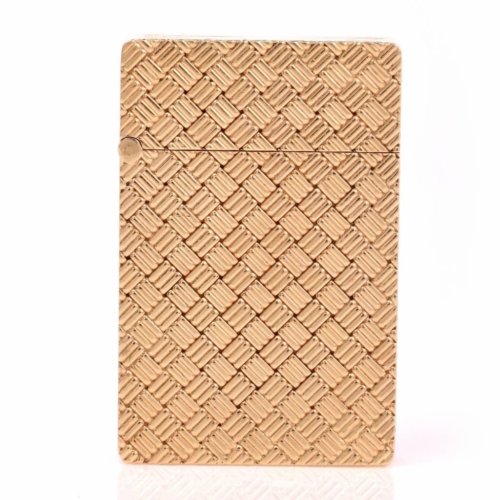 This 1960's lighter of immaculate craftsmanship in rendered in solid 14K yellow gold, weighing 46.9 grams. The artistic basket weave pattern on both sides creates an ornate, stylish design. This collectible piece functions with lighter fluid and