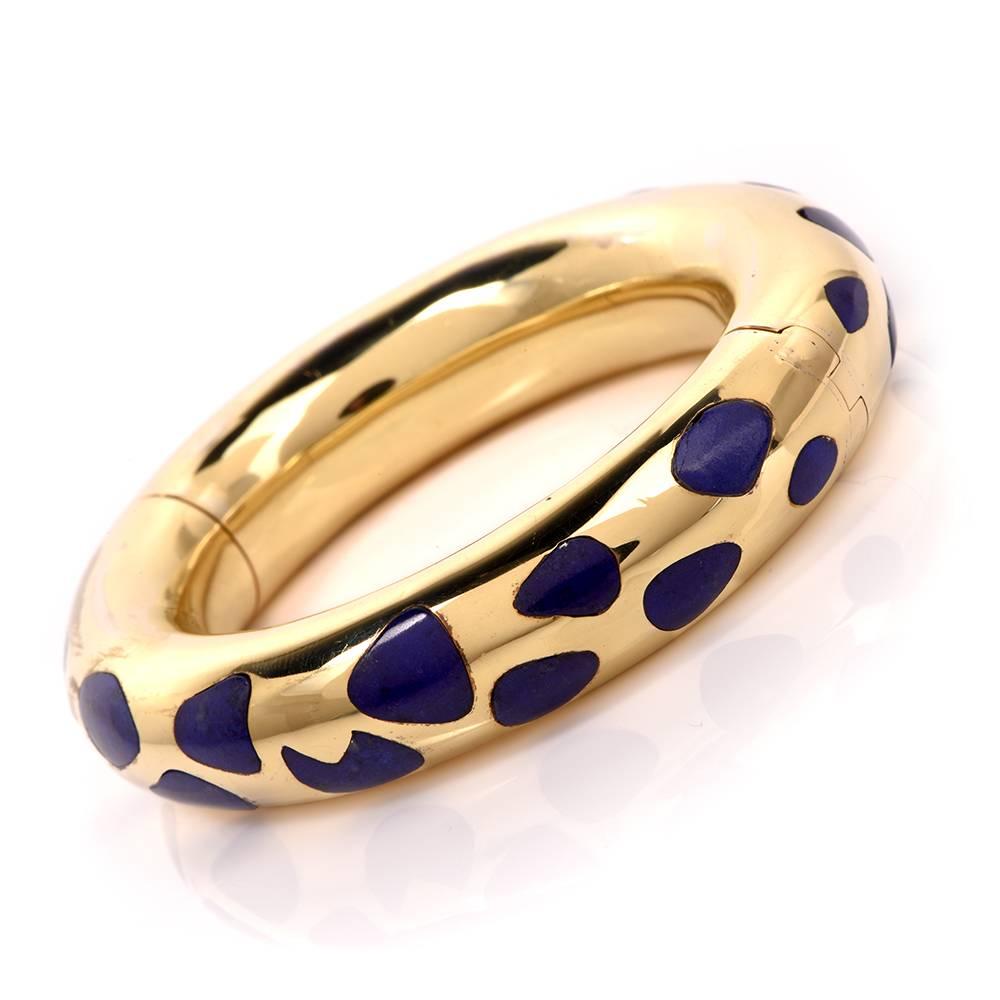 This collectible Tiffany & Co. bangle bracelet circa 1980’s is crafted in 18K yellow gold by Angela Cummings, featuring chic fluid shapes inlaid with genuine lapis lazuli. This item is in excellent condition.

Measurements: 15mm width 13mm high.
