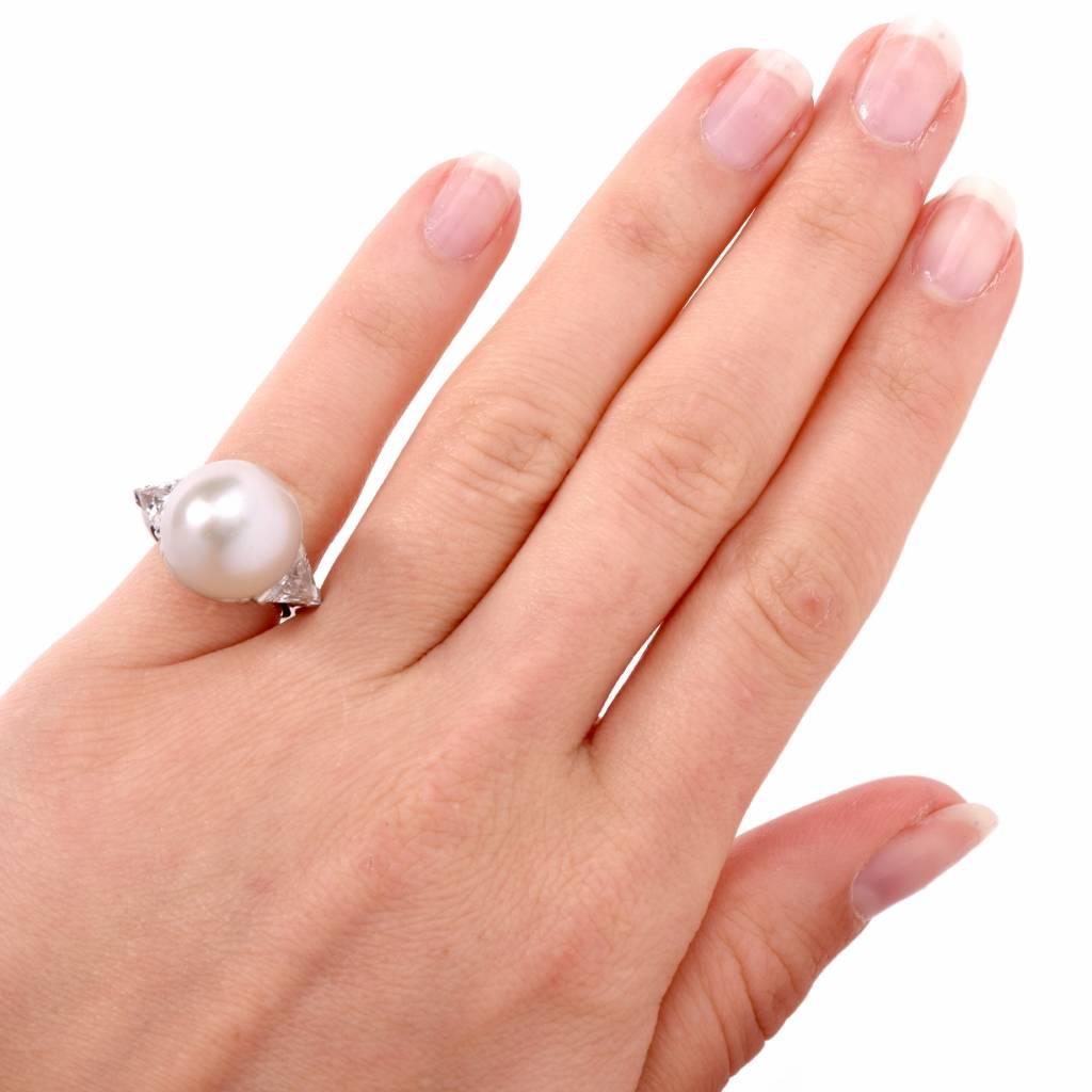 This exquisite cocktail diamond pearl ring is crafted in solid platinum. This cocktail ring exposes a 14mm lusterous South Sea pearl of excellent nacre, positioned between ‘knife-edge’ design, delicately shielded shoulders with a pair of