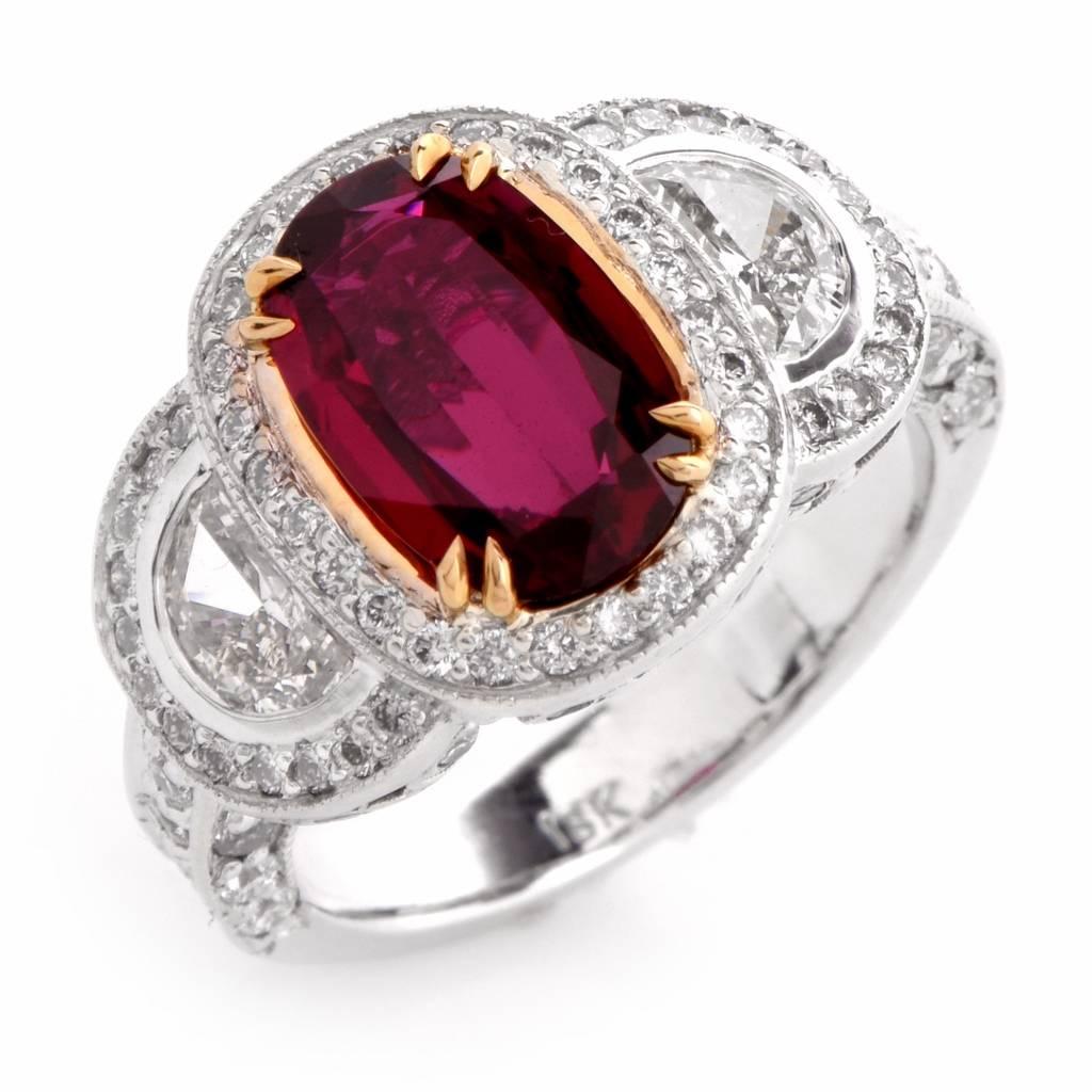 This captivating estate ring is crafted in solid 18k white gold and weighs approximately 7.4 grams. It is centered with a genuine oval faceted ruby, of the most popular 'pigeon blood' red color, approx.2.00cts Secured by four yellow gold paw-prongs,
