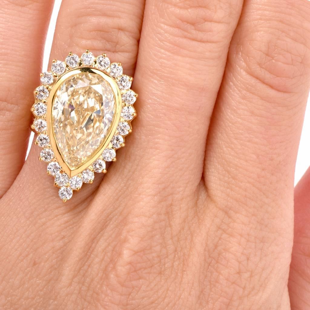 This exquisite estate cocktail / engagement ring is crafted in solid 18k Gold. It is centered with a genuine pear shape GIA certified natural light yellow color diamond approx.9.36 cts. graded VS1 Clarity. It is surrounded by 23 genuine round cut