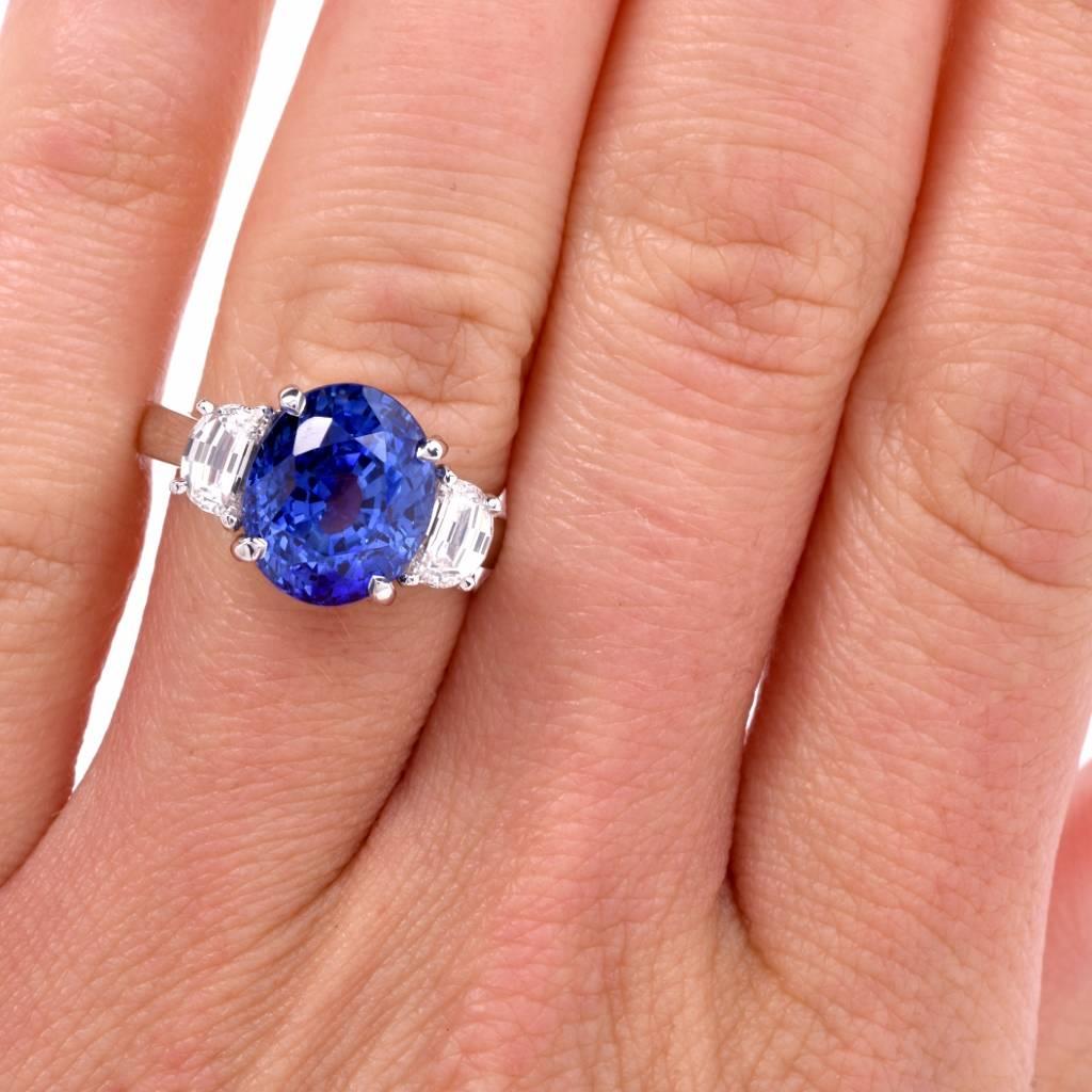 This sparkling Sapphire diamond ring is crafted in solid platinum. It exposes at the center a natural corundum sapphire of stunning blue color with high transparency, measuring 11.02 x 9.40 x 8.4mm, weighing approx. 6.70cts. It is flanked by a pair