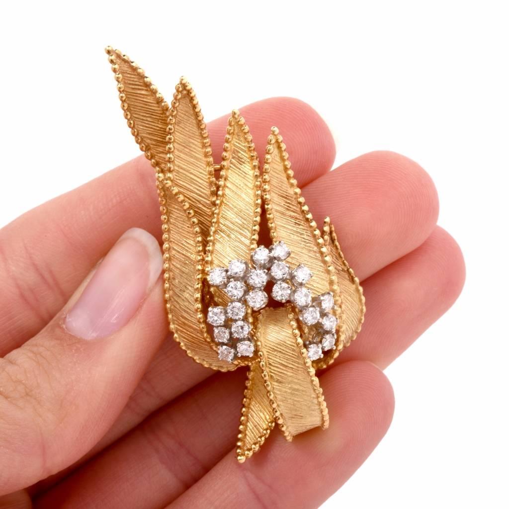 This 1960’s vintage pin brooch is crafted in finely textured 18K yellow gold. It depicts a number of romantically suspending leaves enriched with a diamond 'floral wreath'  composed of prong-set round-faceted diamonds, weighing totally 0.95cts,