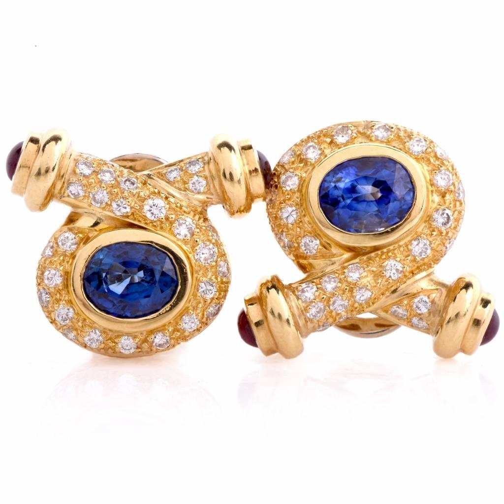 These stunning circa 1980's clip on earrings are centered with 2 genuine oval cut vibrant Sapphires approx: 3.00cttw, bezel set and adorned with 4 genuine round cabochon Rubies approx:0.60 cttw, bezel set and 52 genuine round cut Diamonds approx: