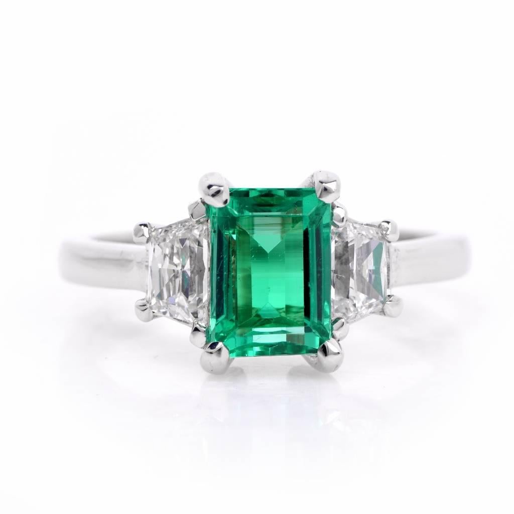 This gorgeous three stone ring is centered with 1 genuine emerald cut Colombian emerald  approx: 1.67ct, prong set, adorned by 2 genuine trapezoid cut Diamonds on the sides approx: 0.60cttw, H-I  color, VS1 clarity, prong set. This Three stone