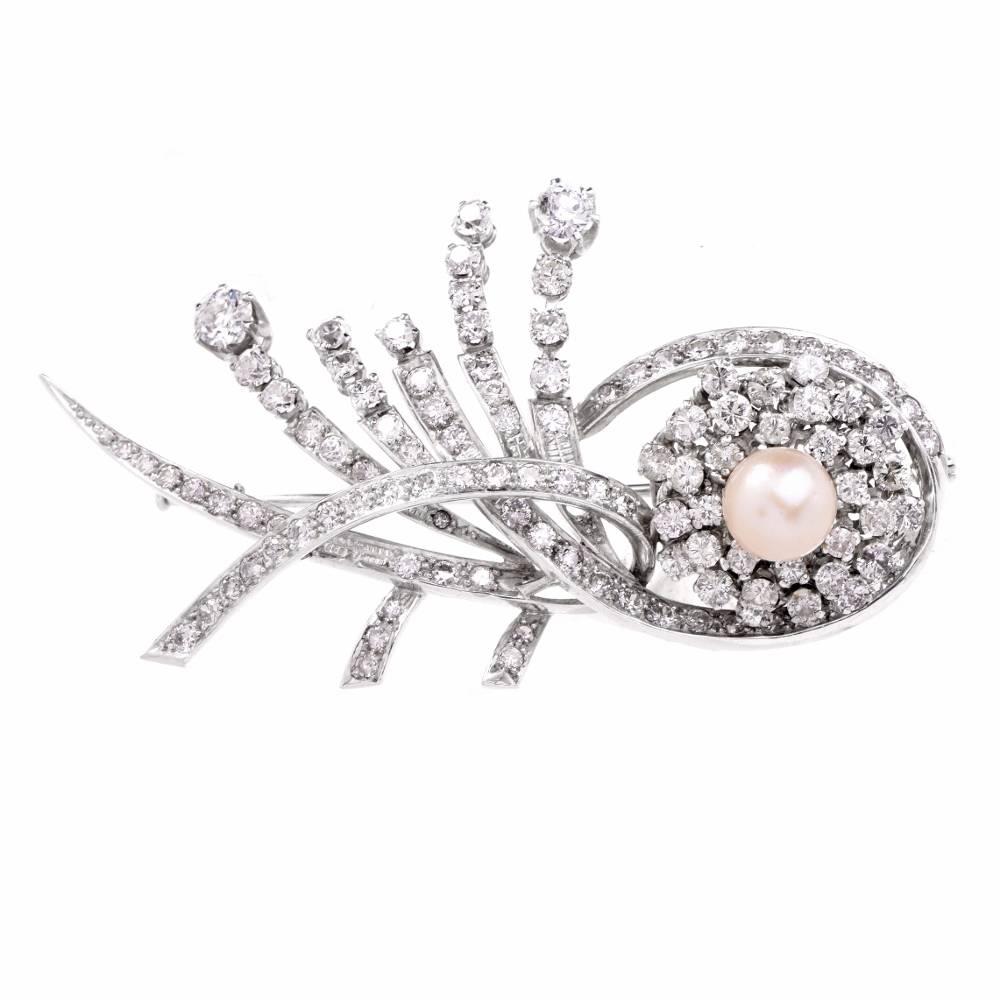 This alluring 1940’s vintage pin brooch of opulent aesthetic is crafted in a combination of platinum It depicts a precious diamond & pearl flower amidst several sparkling and romantically scrolled stems, bearing diamond ‘buds’. The enchanting