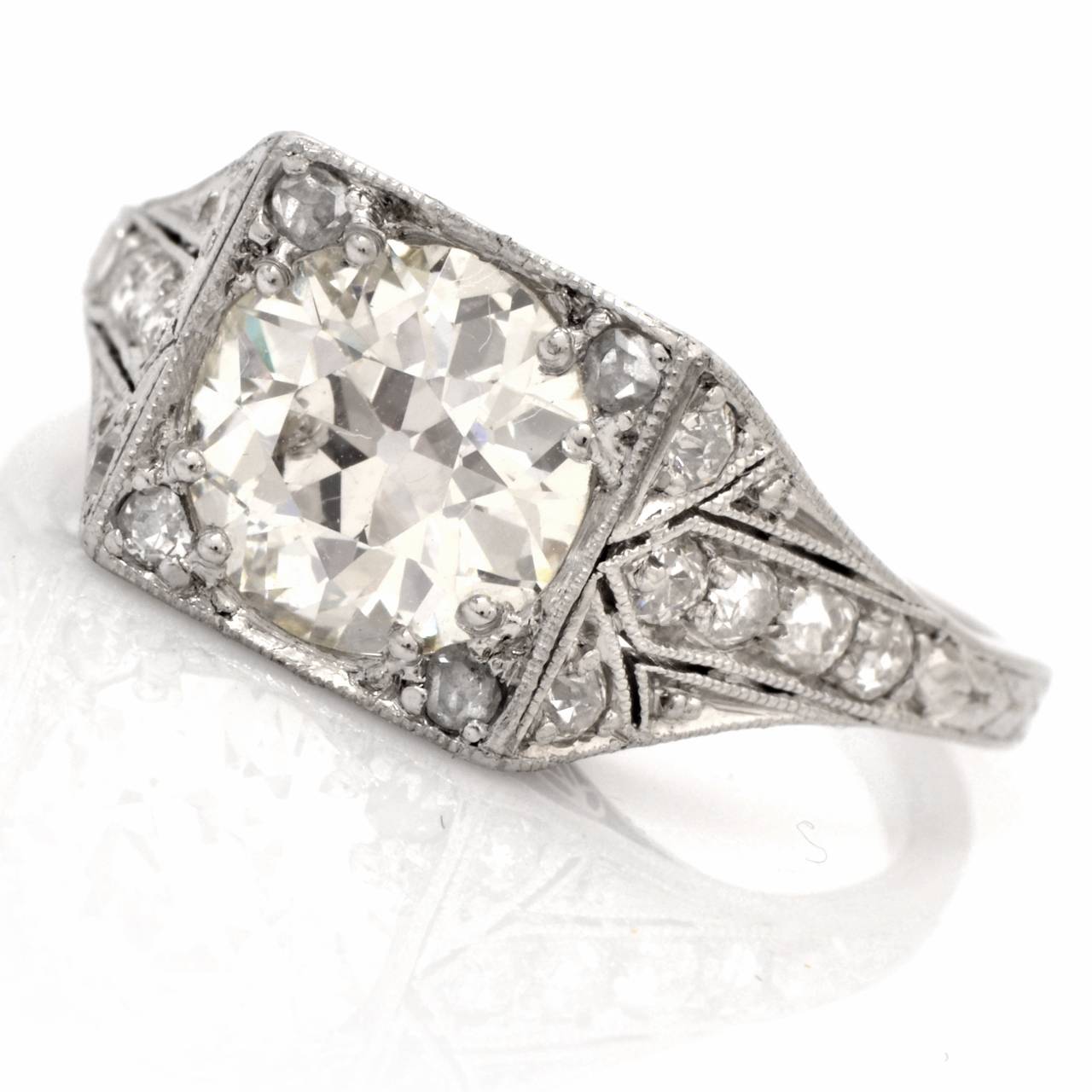 This stunning , authentic Art Deco engagement ring with diamonds is crafted in solid platinum, weighing 3.4 grams. Incorporating  quintessentially Art Deco features, this alluring engagement ring is designed with a quadrangular plaque, exposing an