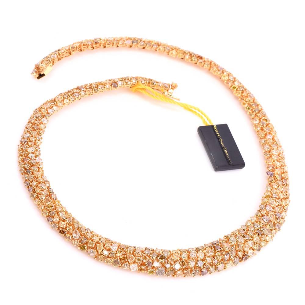 This  intriguing 21st Century fancy diamond cluster necklace of fascinating sparkling aesthetic is crafted in solid 18K yellow gold, weighing 92.9 grams and measuring 16.5 inches long and 15 -10 mm wide. The captivating necklace of tapering width 