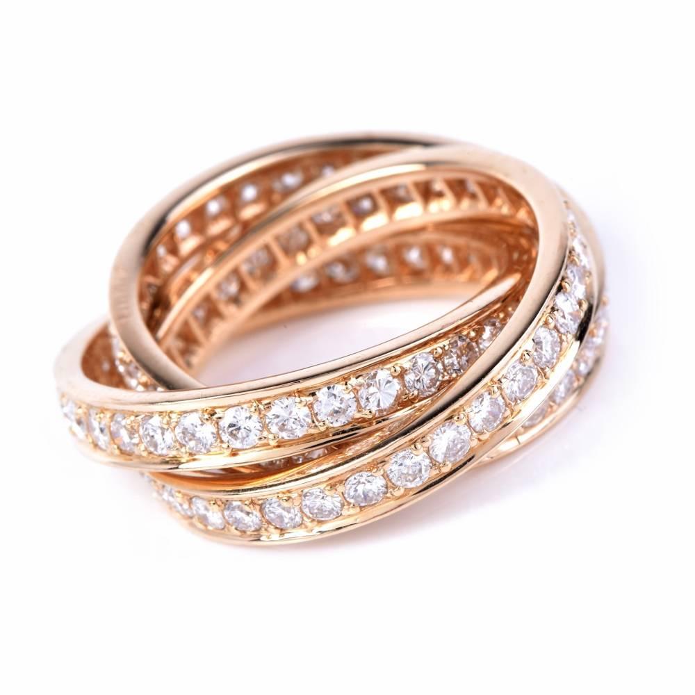This authentic Cartier eternity Rolling ring from the Trinity collection is crafted in Solid 18K yellow gold, weighing 8.1 grams.  The three rings are cumulatively adorned with approx. 96 round diamonds approx.1.60cts graded F-G color and VVS1-VVS2
