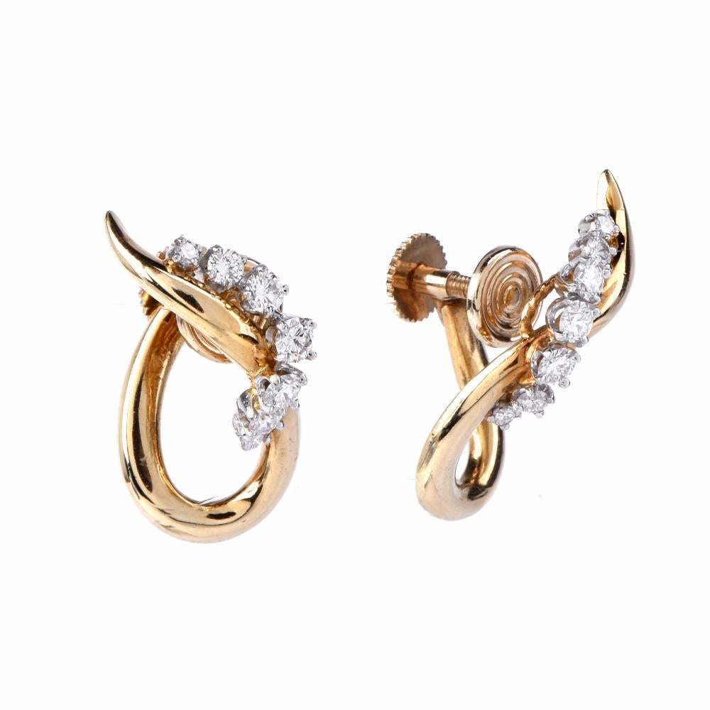 These vintage earrings crafted in a combination of platinum and 18K yellow gold are designed as romantically scrolled profiles, simulating stylized teardrops, each enriched with 7 graduated round-faceted diamonds, weighing approx. 0.50cts, graded
