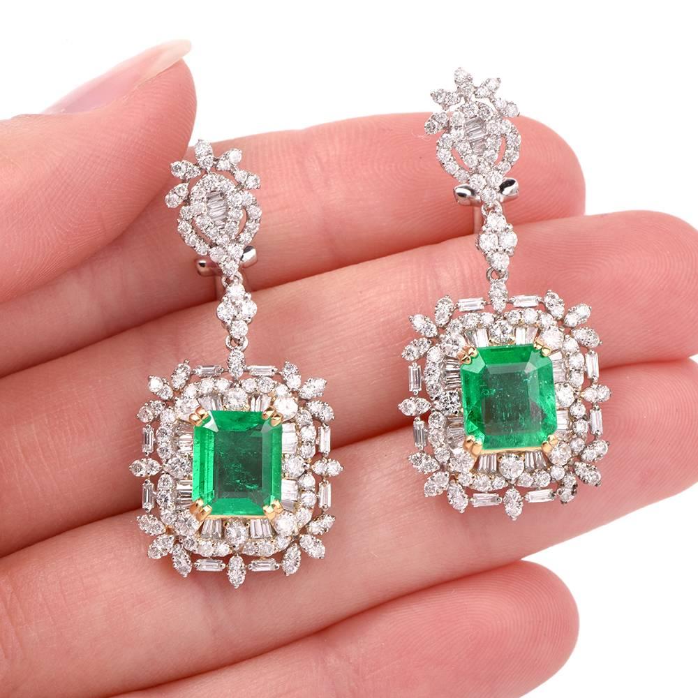 These elegant sparkeling dangle earrings are crafted in solid 18K white gold. Centered with 2 genuine emerald cut Emeralds (with natural inclusions and minor cedar oil treatment) approx: 4.38cttw, yellow gold prong set. Accented by 197 genuine round