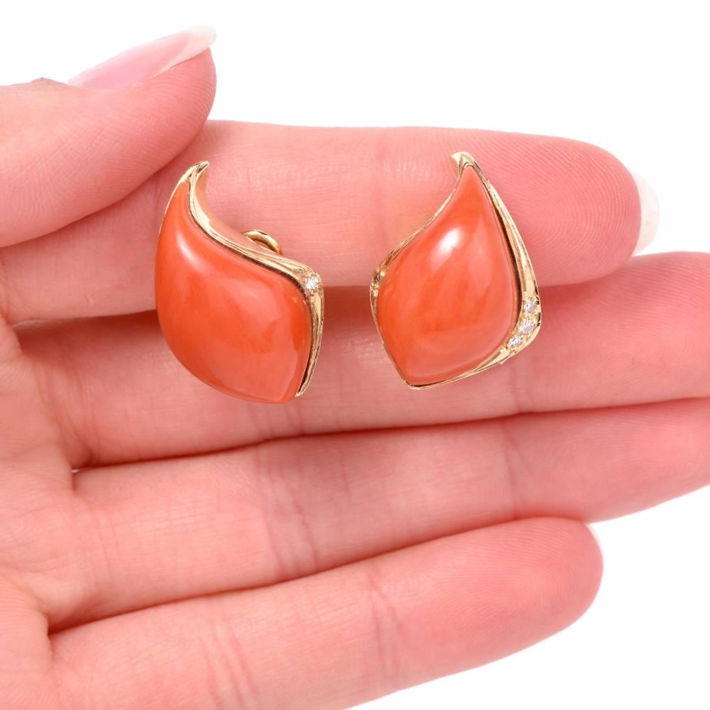 These hand crafted 1960's earrings are centered with 2 genuine natural high quality red Corals measuring apron. 22mm by 12mm, bezel set and adorned with 8 genuine round cut Diamonds approx: 0.15 carats , H-I color, VS clarity, prong set. These