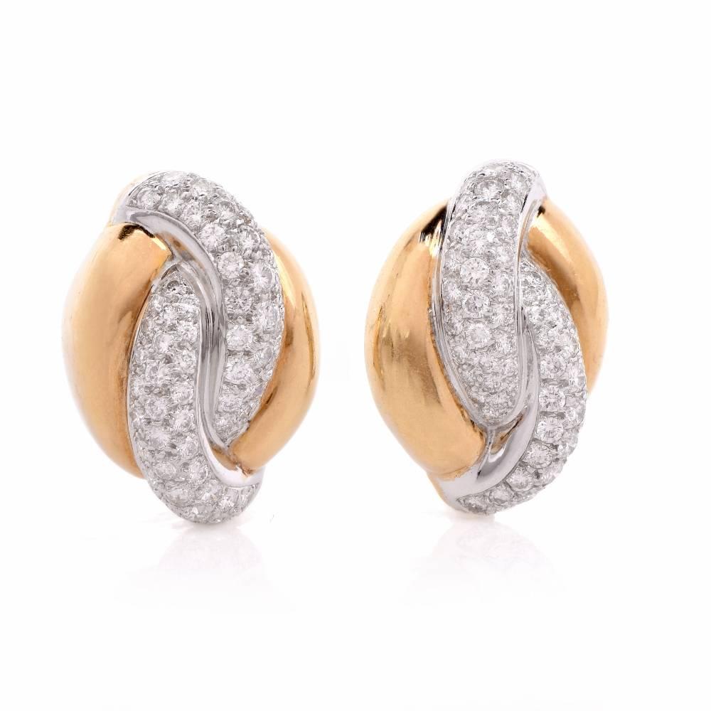 These  estate earrings crafted in a combination of solid 18K yellow and white gold with decorative design with overlapping scrolls, weighing 19.8  grams and measuring 30 x 20 mm. The centrally positioned white gold scrolls on the earrings are set