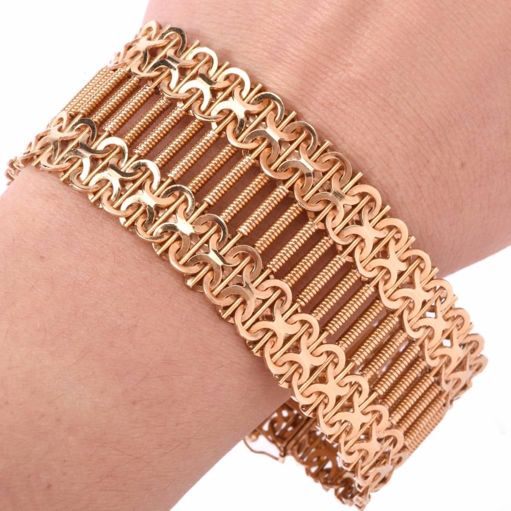 This Vintage Retro bracelet of artistic design and workmanship is handcrafted in solid 18K yellow rose gold. It depicts a fine assemblage of ornate, Etruscan style, cylindrical profiles in the center within captivating borders composed of