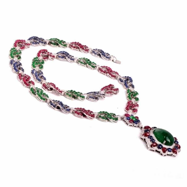 This spectacular multicolored gemstone long necklace pendant  Finely made  in solid 18K white gold. This necklace features a drop pendant that is centered with a  large genuine  cabochon pear shaped emerald approx. 53.50 carats. The stunning emerald