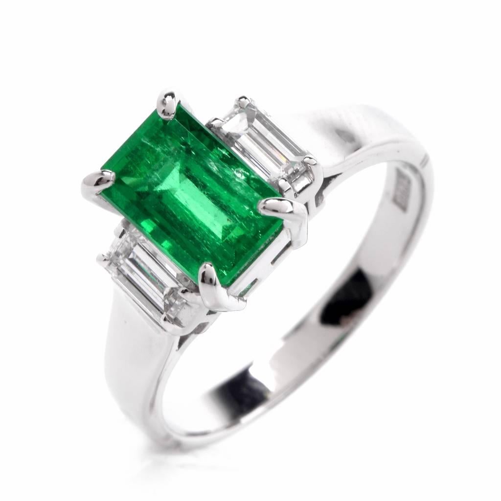 This sparkling Colombian diamond three stone ring is crafted in solid platinum. It exposes at the center a natural emerald of stunning green color with high transparency, weighing approx. 1.66 carats. A pair of genuine high quality baguette cut