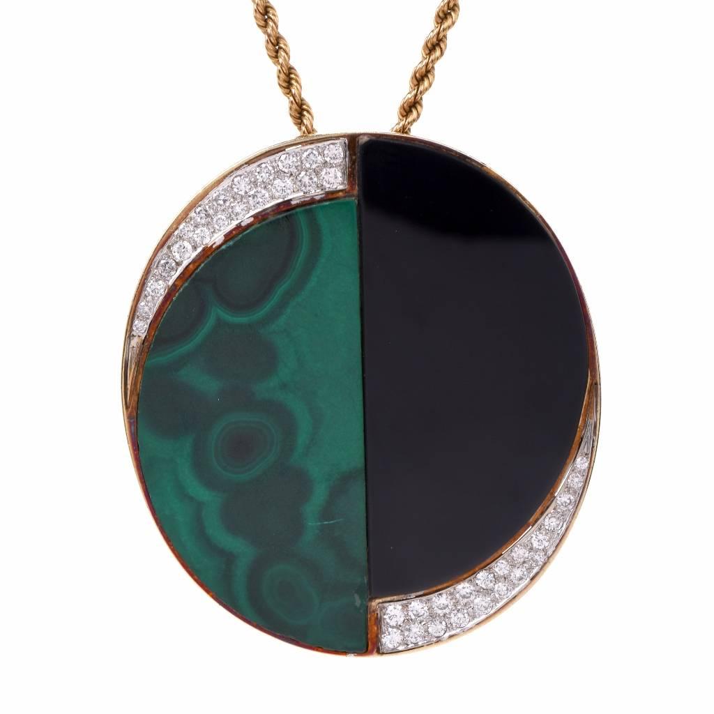 This 1070's vintage brooch and pendant of simple elegance is crafted in 18K yellow gold, designed by Triumph Co as an ovular plaque, set with crescent-shape carved malachite of two distinct colors, enriched with pave diamonds. The particularly