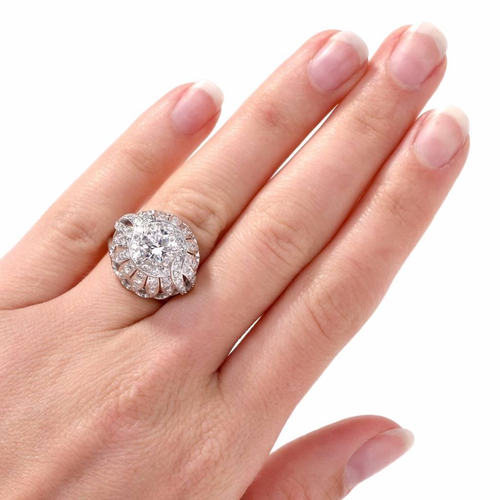 This alluring vintage filigree engagement / Cocktail ring with openwork floral motif profiles is designed as a gracefully domed plaque, depicting an assemblage of openwork, diamond-studded floral motif profiles. Crafted in solid platinum, it weighs
