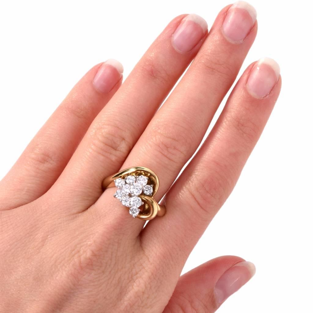 This estate diamond cluster ring of romantic inspiration is crafted in 18-Karat yellow gold, weighing 12.3 grams. Designed as a stylized heart motif profile, it is enriched with 10 high quality round-faceted diamonds forming a sparkling cluster