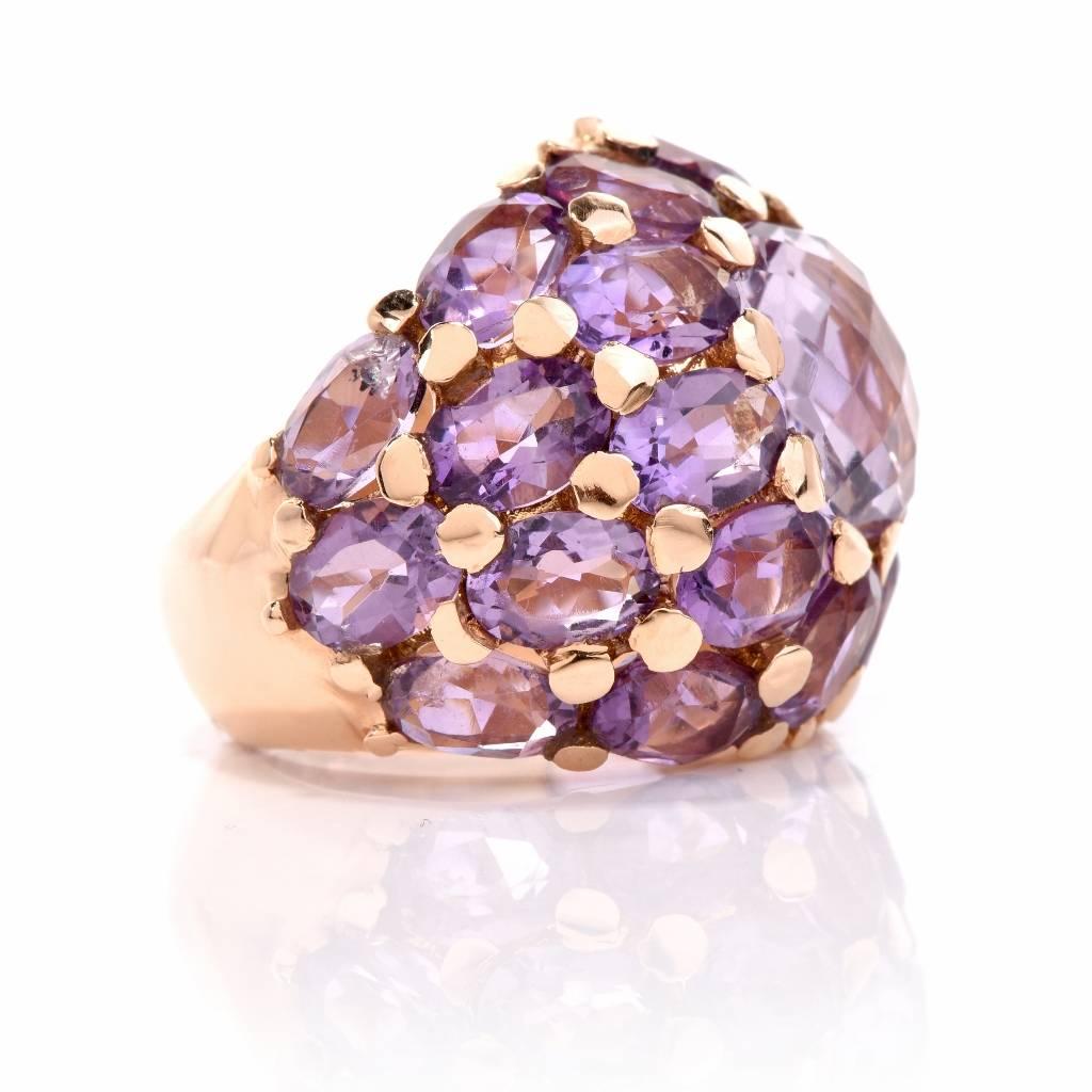 This extravagant Estate Amethyst ring is crafted in solid 18K yellow gold and displays a chic dome design centered with 1 genuine round faceted Amethyst approx: cttw, prong set .

It is furthermore embellished by a cluster of 24 genuine round and