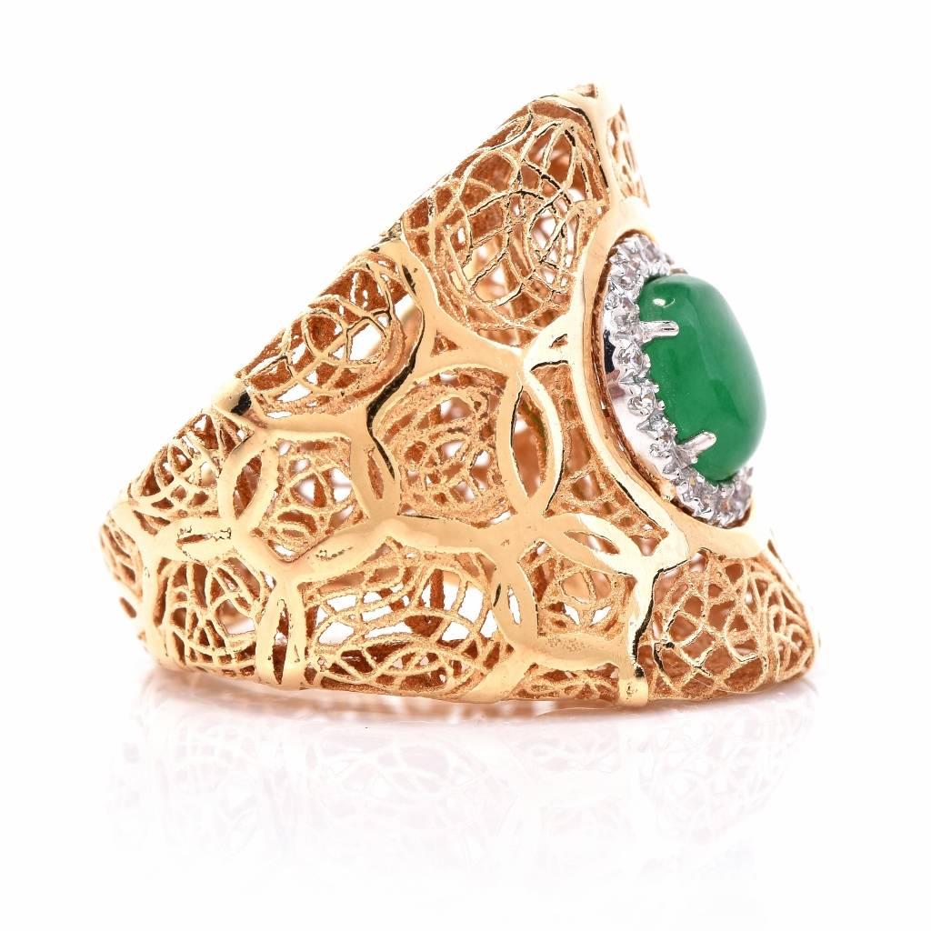 This refined Estate Diamond & Jade filigree cocktail ring is handcrafted in solid 18K yellow gold with white gold details.
It is centered with 1 genuine oval cabochon Jade approx: cttw, prong set, encircled by 16 genuine round cut Diamonds