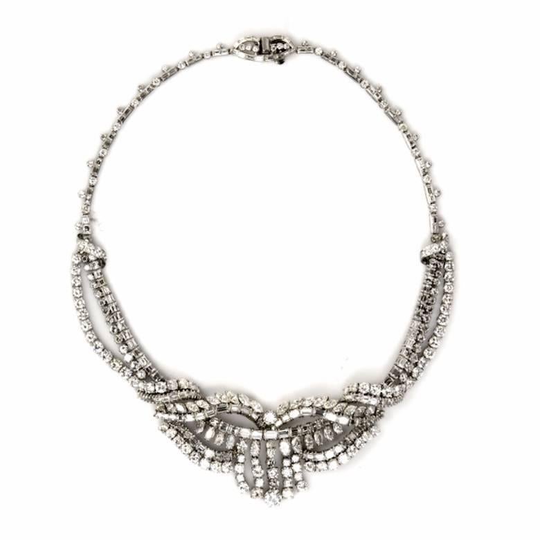 This classically distinct Antique diamond necklace is artfully crafted in solid platinum. Depicting a captivating central decor with cascading diamond fringes, is resplendent in 124 genuine round-faceted diamonds; 182 genuine squared emerald cut