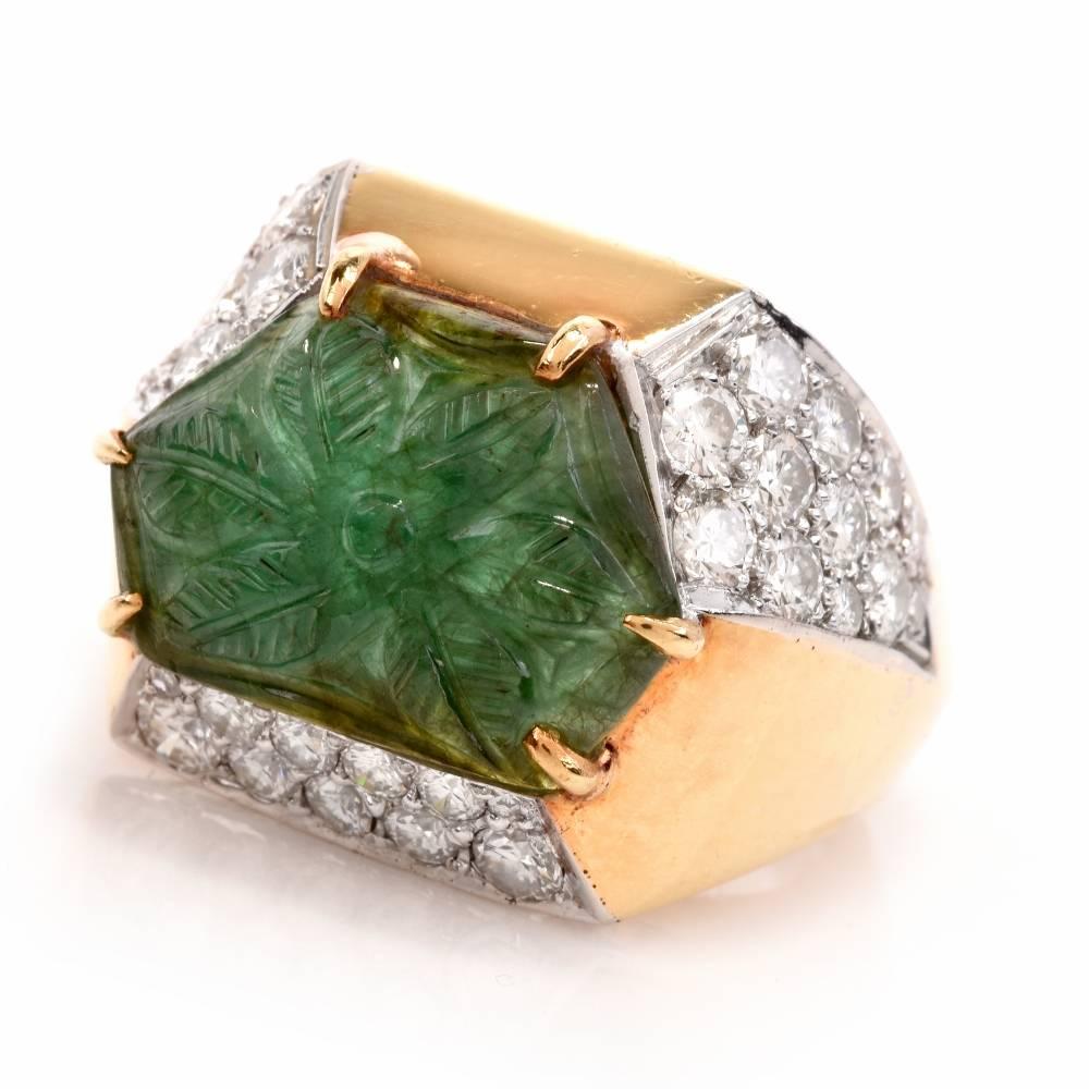 This opulent vintage Retro 1970's ring of color-contrasting aesthetic exposes an ornate, hexagonal-cut emerald artistically carved with a 5-petal flower and secured with 6 paw-prongs. The genuine emerald is positioned between a polished yellow gold