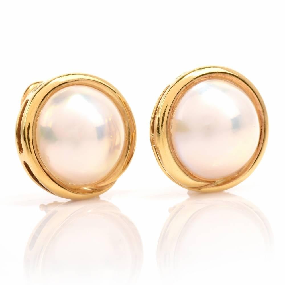 These estate clip-on earrings with a pair of lustrous Mabe pearls are crafted in 18-karat yellow gold and weigh together 12.1 grams. These genuine mobe pearls measure 13 mm in diameter and are of an echanting white with a pinkish hue color, They are