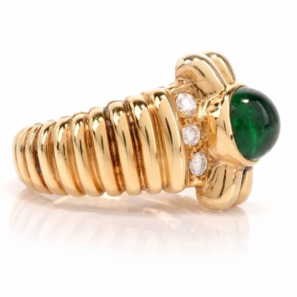 

This estate emerald and diamond ring is crafted in solid 18karat polished yellow gold.  It is centered with  a high quality Colombian emerald cabochon  weighing  approx. 1.05 carats at the center ornately ridged throughout creating a fascinating