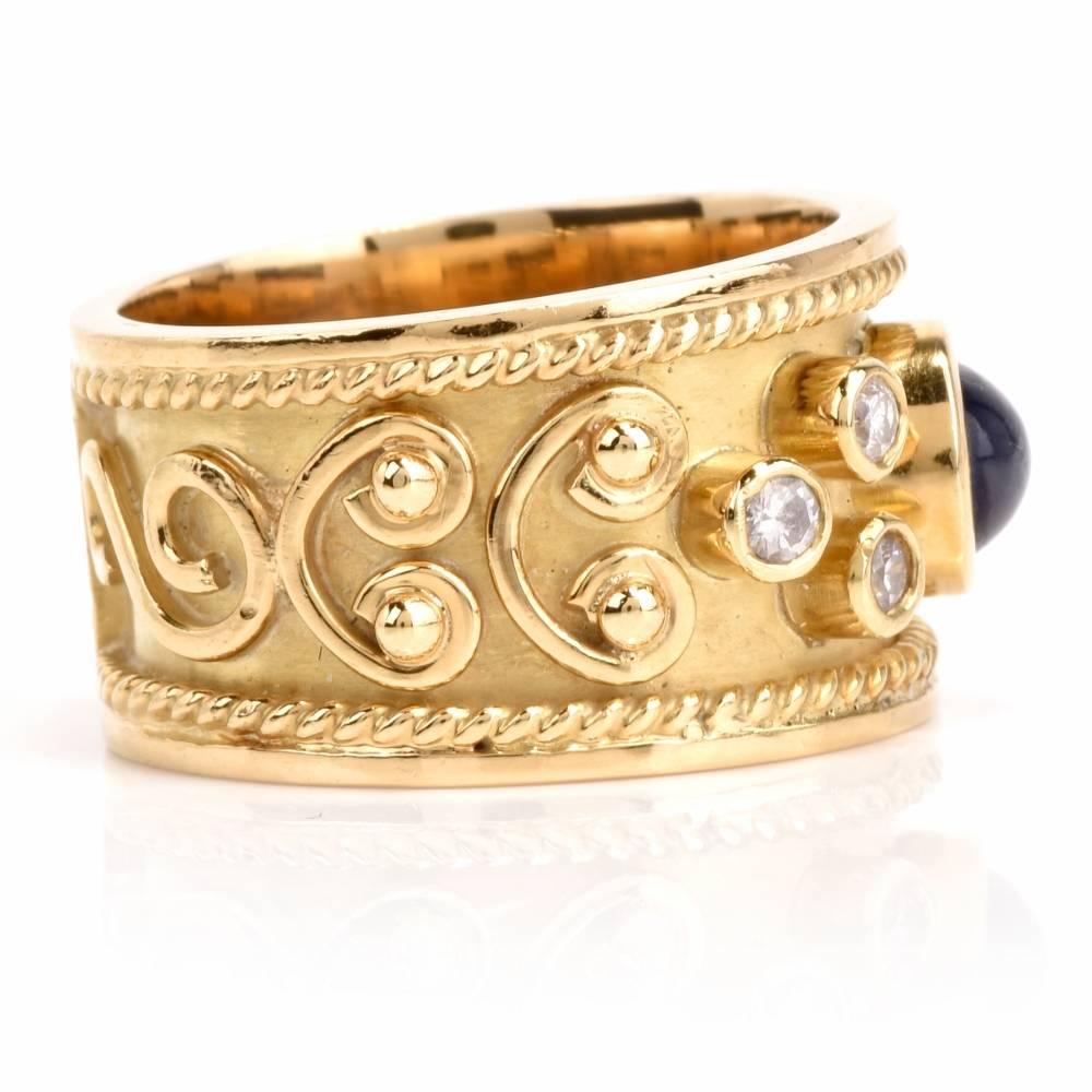 Artfully decorated with floral motif relief technique all around, this estate wide band ring is enriched with a bezel-set teardrop shape blue sapphire cabochon, weighing 0.90 carats, and 4 round-faceted diamonds, weighing totally  0.15 carats, grade