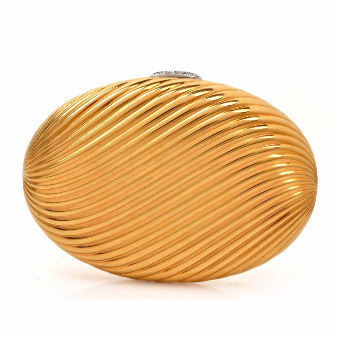 This aesthetically captivating and High polished compact box designed and signed by Bvlgari is crafted in solid 18K yellow gold, weighing 187.7 grams and measuring 3.5" x 2.5" x 0.60".  Designed as a gracefully feminine ovular