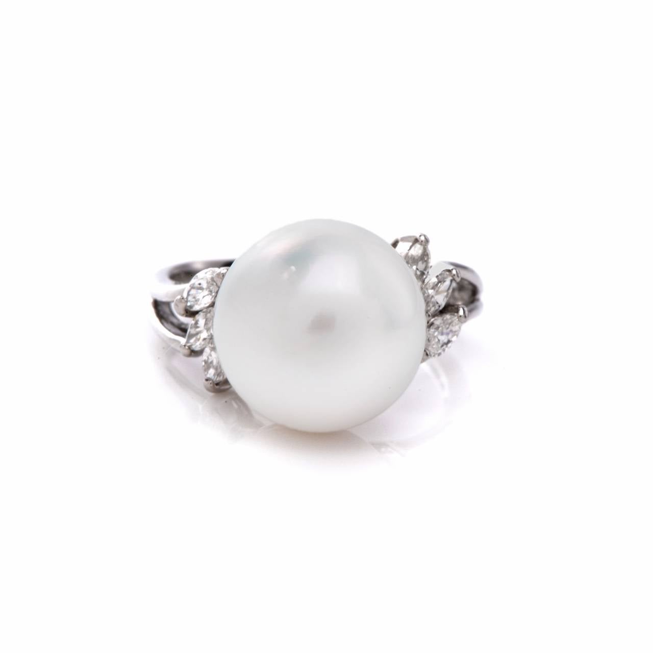 This classically distinct cocktail ring is crafted in solid platinum, weighing 5.8 grams.  It exposes a lustrous 12 mm South Sea pearl of excellent nacre, flanked by trios of 'en diagonal' mounted marquise diamonds.  The latter weigh cumulatively